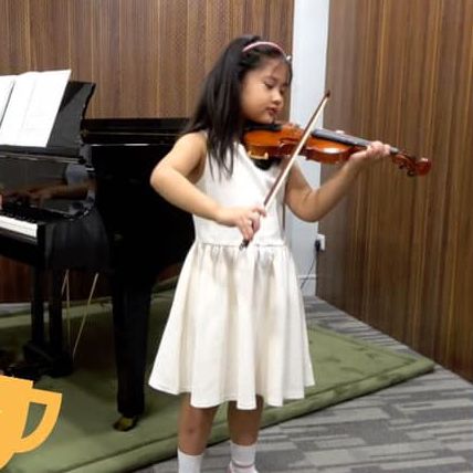 A girl playing the violin for an examination.
